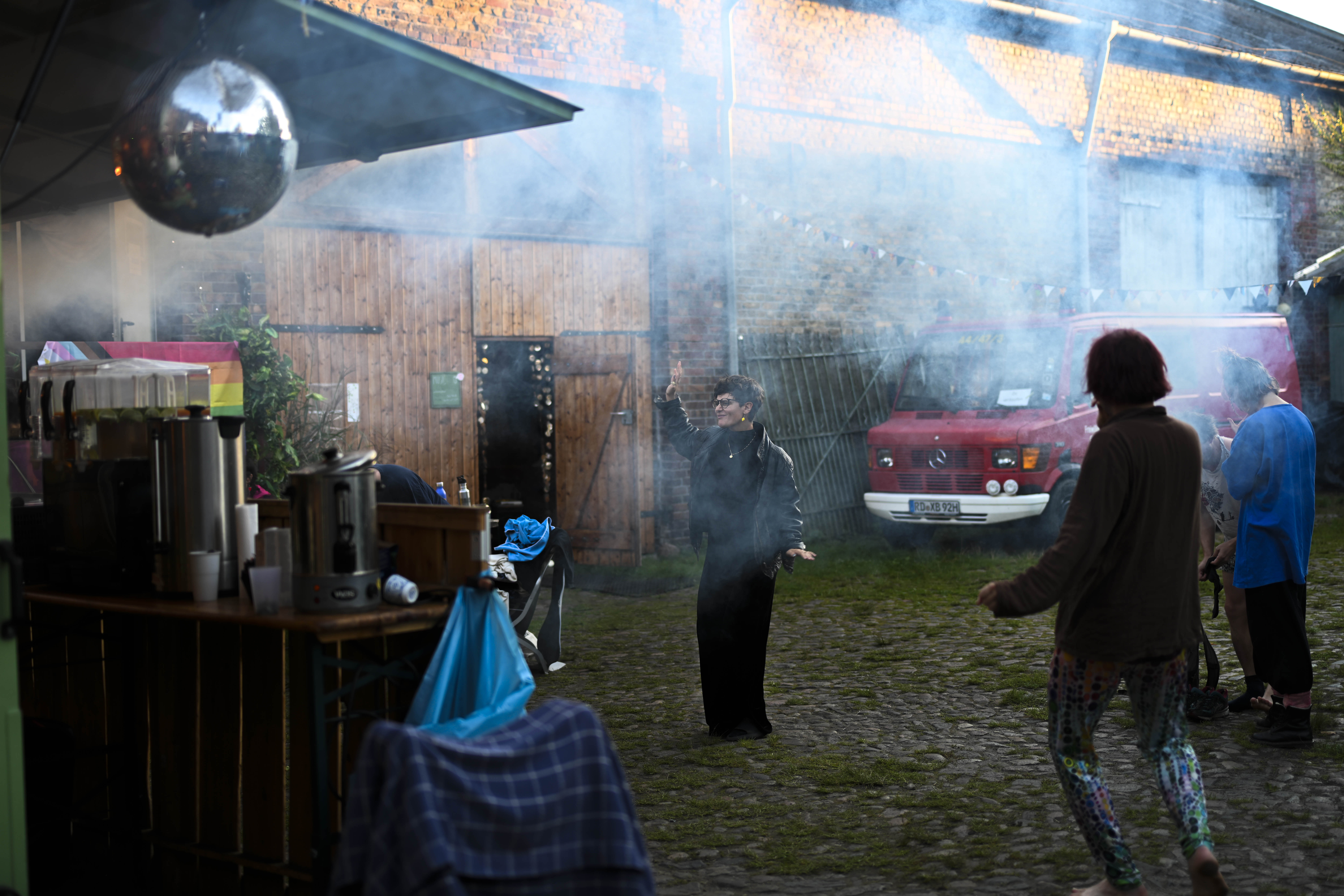 Eine Person steht in Mitten von Nebel auf einem Outdoor Platz und tanzt versunken