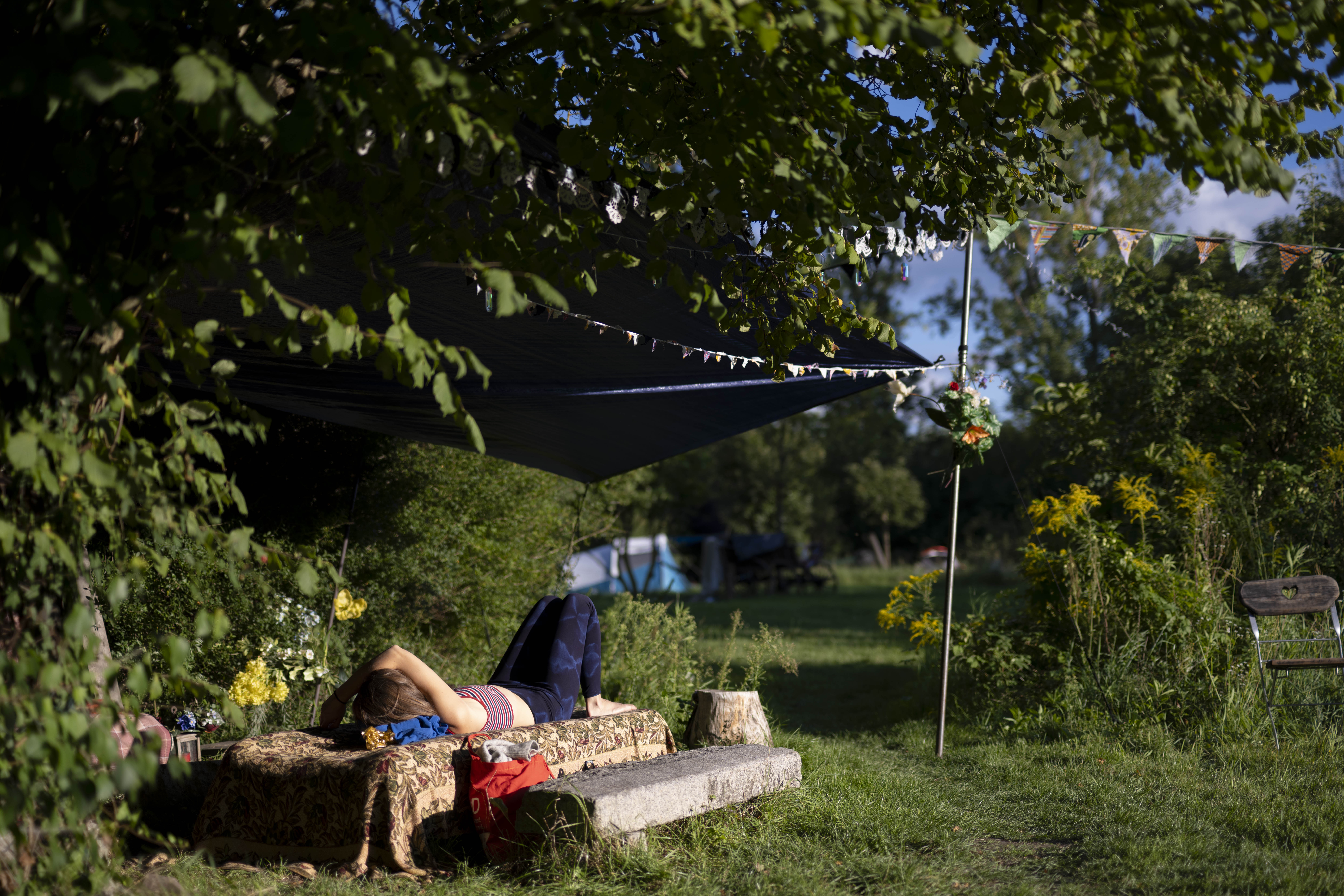Eine Person entspannt sich in der Sonne auf einer Bank liegend