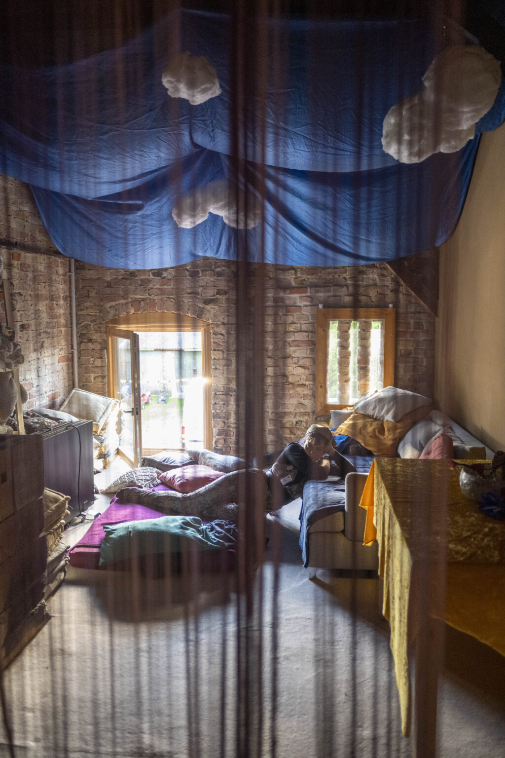 Blick durch einen transparenten Schleier auf einen Kuschelbereich